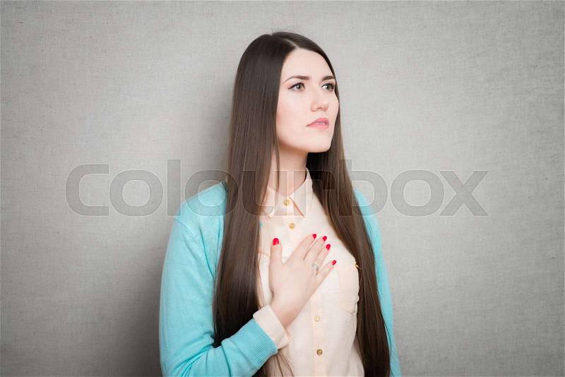 Woman feeling heart pain and holding her chest, stock photo