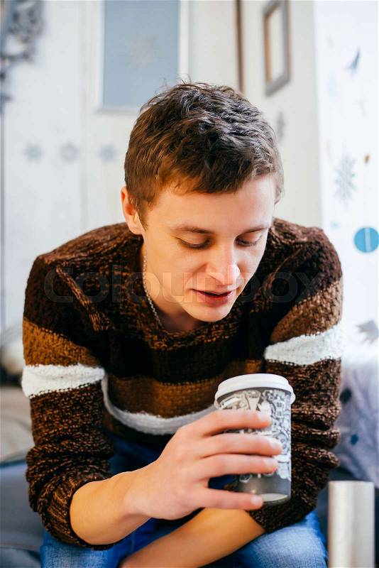 Portrait of handsome guy drinking coffee in home kitchen, stock photo