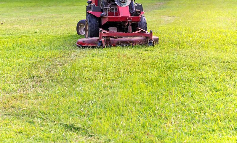Closeup of mower cutting the grass in public park, stock photo
