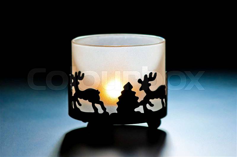 Glass candle holder with a burning candle, stock photo