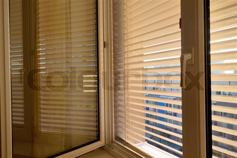 To protect against heat and sun blinds are attached to a window, stock photo