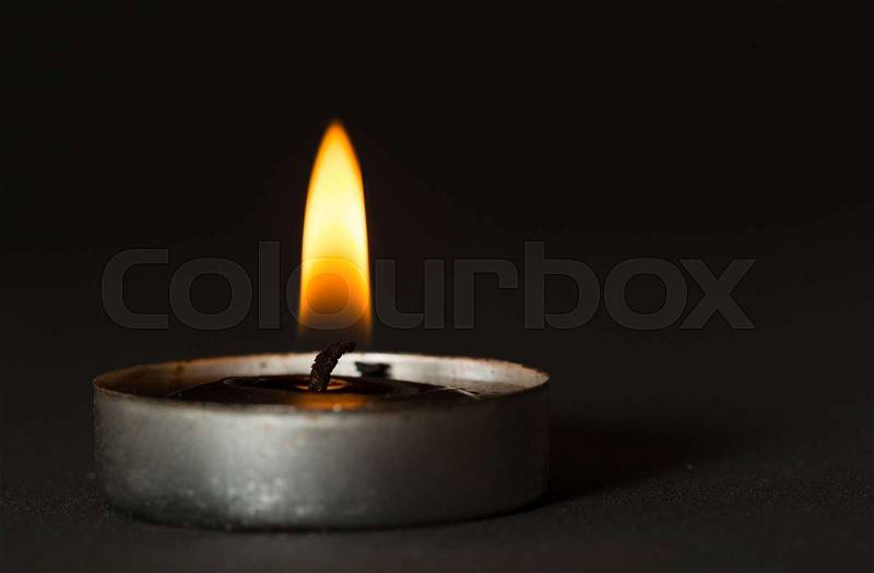 Black candle with black background, stock photo