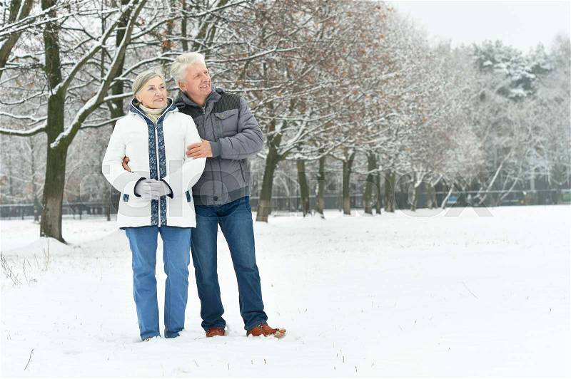 Portrait of elderly couple having fun outdoors in winter forest, stock photo