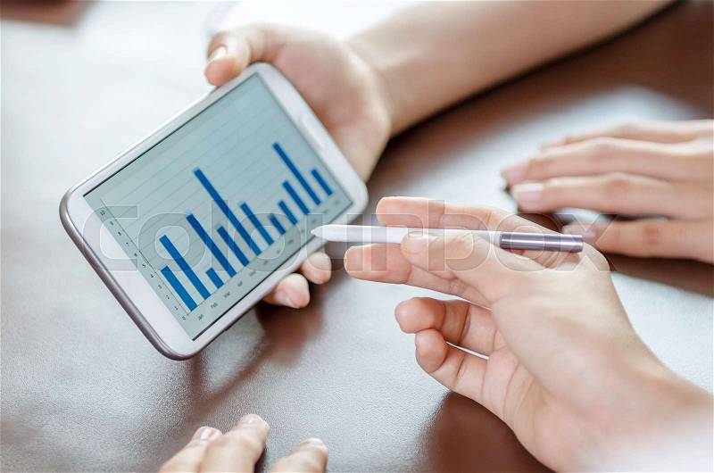 Close-up of women using tablet with stylus pen, stock photo