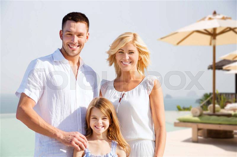 Summer holidays, travel, tourism and people concept - happy family on vacation over resort beach background, stock photo