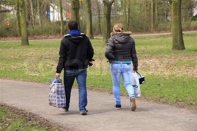 Couple, man and wife, walk to the pool of water for fishing in Abbenbroek in spring, stock photo