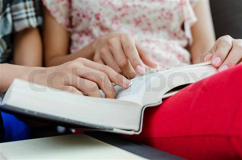 Closeup of teenage girl hands reading the book, stock photo