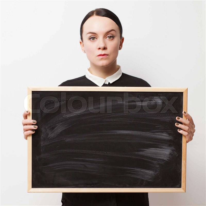 Retro portrait of a strict young woman holding a blackboard, stock photo