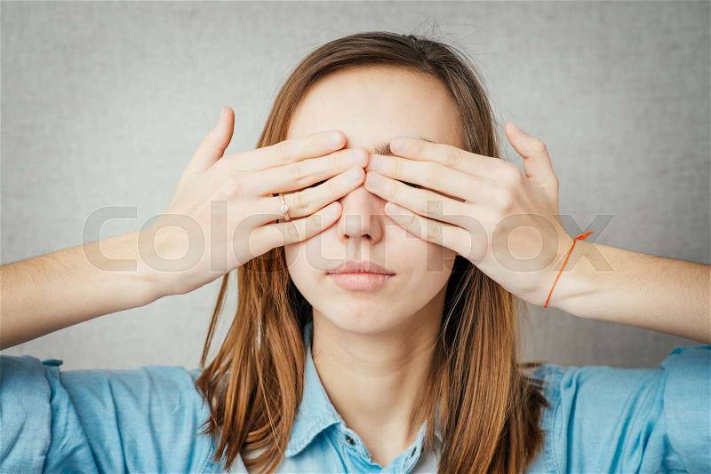 Girl covering her eyes with her hands, stock photo