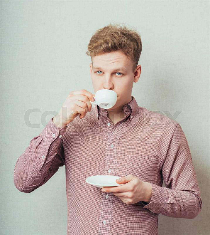 Man drinks coffee from a small white cup of coffee, stock photo