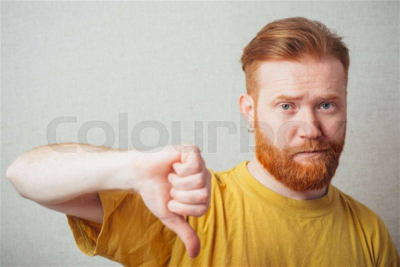 Bearded man showing thumb down, stock photo
