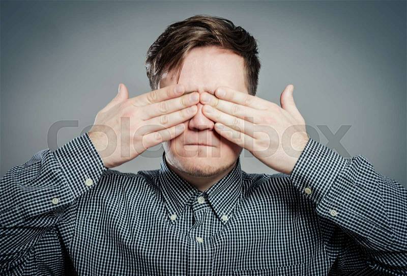 Portrait of a young man with his hand on his eyes, stock photo