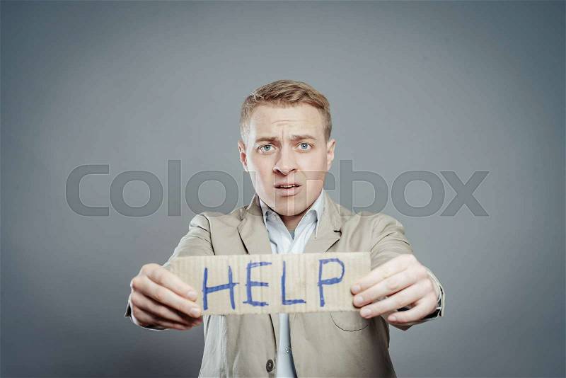 Businessman holding the text help, stock photo