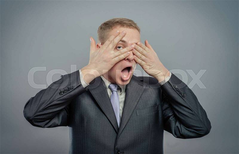 Young scared adult with hand covering eyes , stock photo