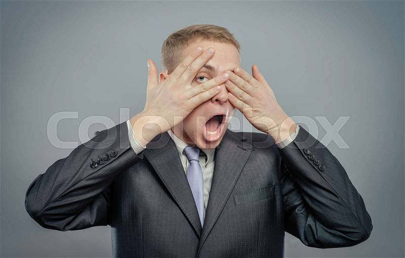 Young scared adult with hand covering eyes , stock photo
