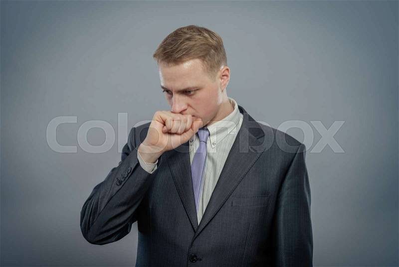 Closeup portrait of an angry guy biting his fist, stock photo