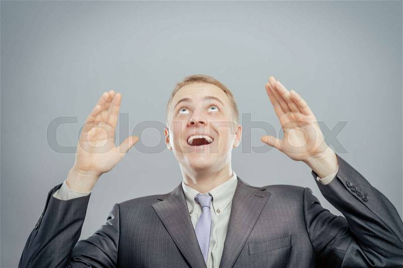 Unsure businessman shrugs his shoulders and throws his hands in the air, stock photo