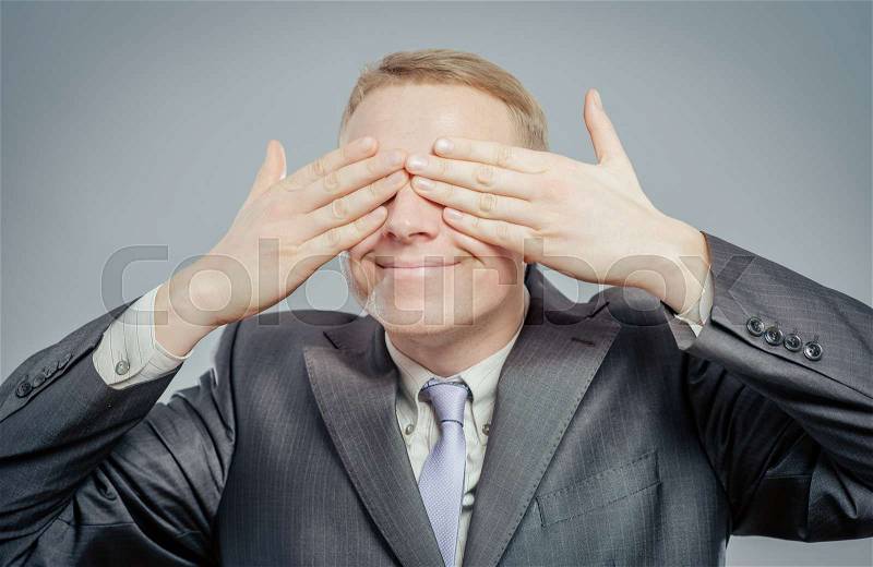 Young businessman put his hands over eyes, stock photo