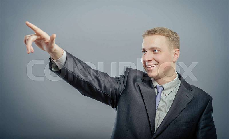 Handsome young business man happy smile point finger to empty copy space, businessman showing pointing up, concept of advertisement product, wear elegant suit and tie, stock photo