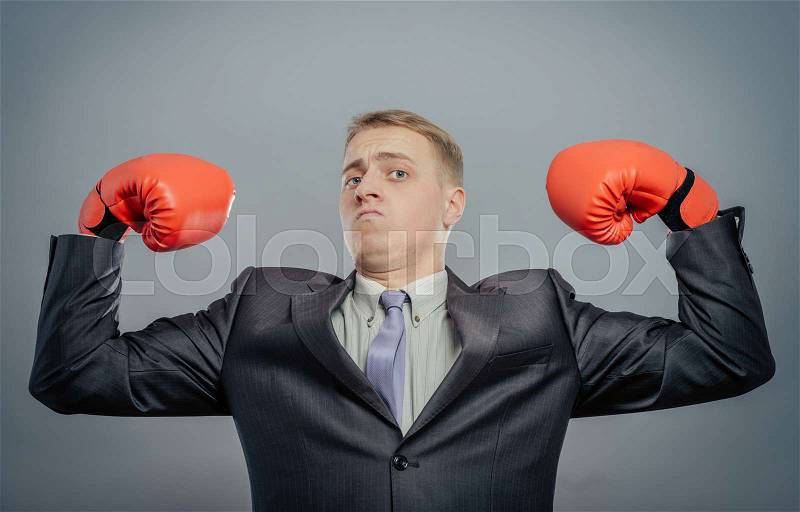 Young man in a suit and boxing gloves, celebrating a win, stock photo