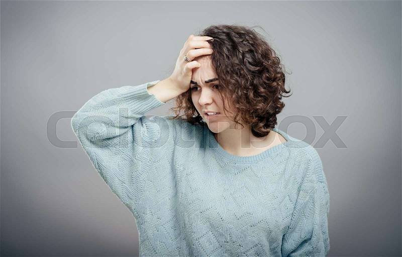 A young attractive woman suffering from illness or headache holding her head. Isolated, stock photo