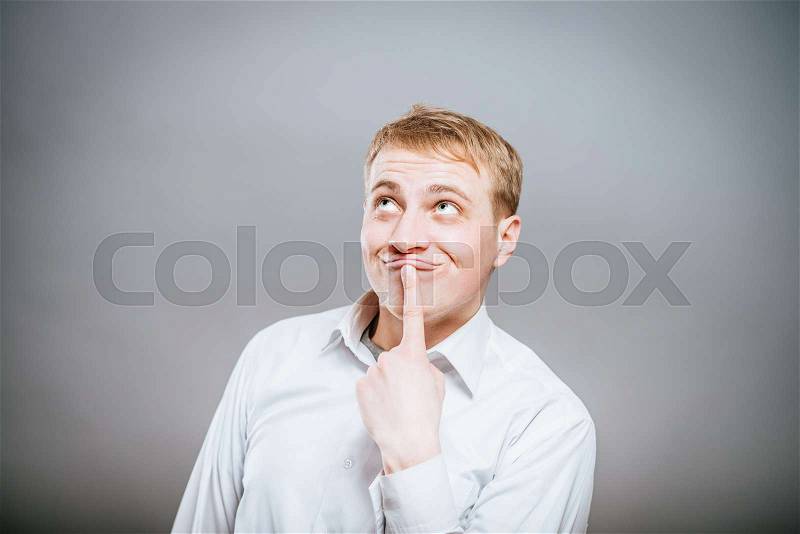 Puzzled handsome young man scratching his head with his hand as he looks at the camera with an uncertain perturbed expression, isolated on white, stock photo