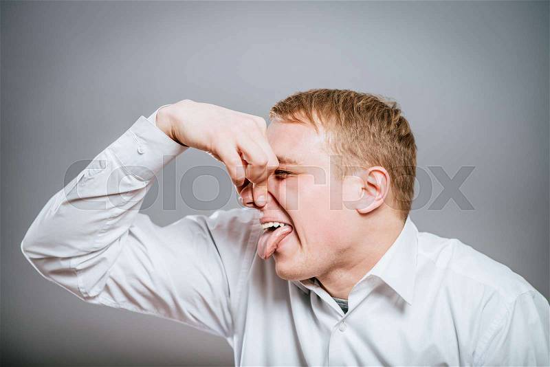Closeup portrait of young man, disgust on his face, pinches his nose looks away, something stinks, very bad smell, situation, isolated. Negative emotion facial expression feeling, stock photo