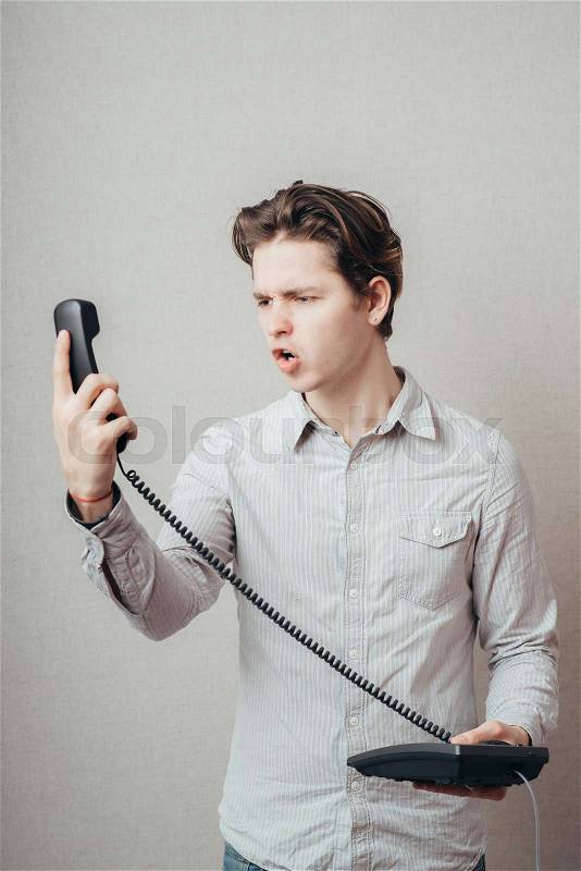 Portrait of young man talking on a vintage telephone , stock photo