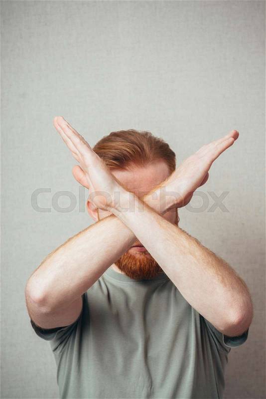 Serious and determined Young hipster red bearded Man makes an X shape with his arms and hands. stop, cross, or, stock photo