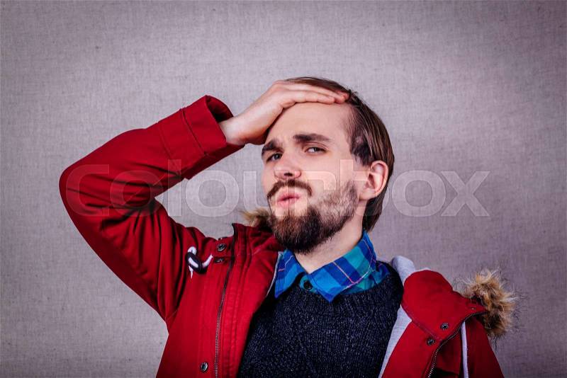 Closeup portrait of a upset young man with hand on his head, stock photo