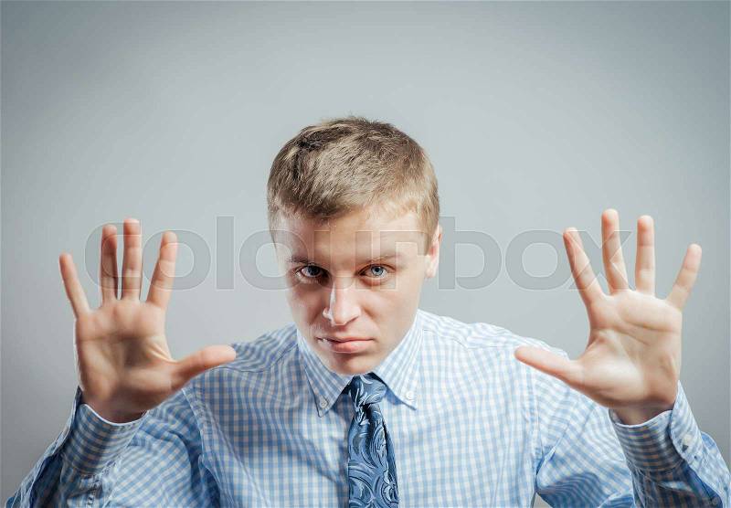 Afraid man in defense attitude gesturing stop with hands, stock photo