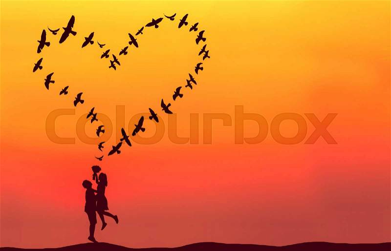 Silhouette of couple in love with heart shaped made by flying birds, stock photo