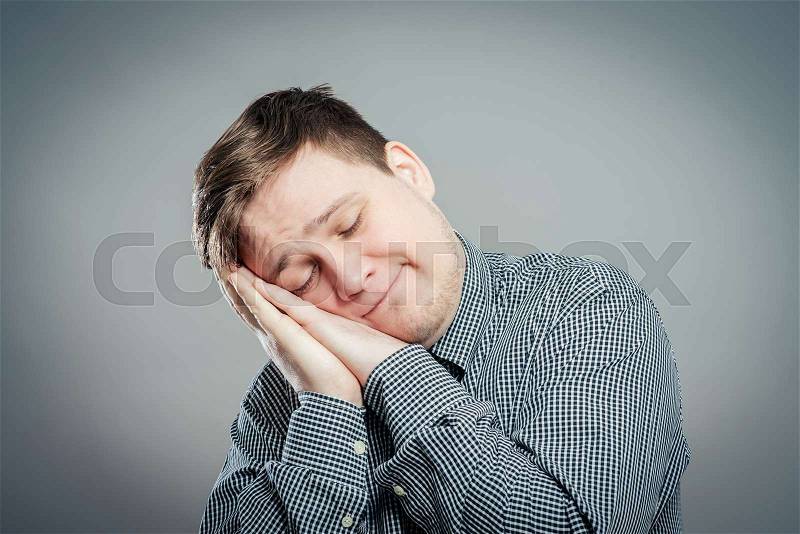 Young Man wants to sleep. Put his head in his hands, stock photo