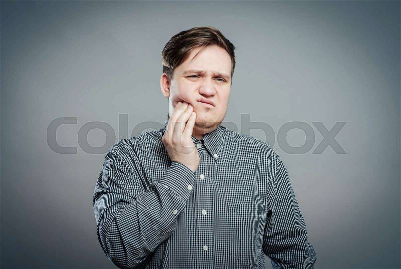 A young man feels toothache, stock photo