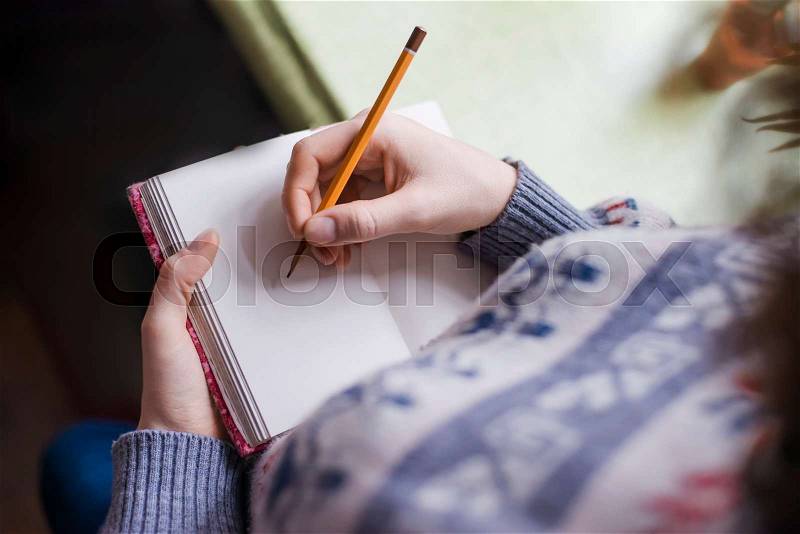 Human hands with pencil writing on paper, stock photo