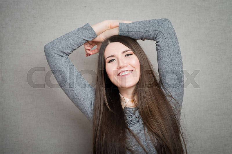 Young relaxed woman with hands behind head, stock photo