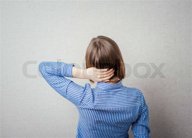 Closeup portrait of cute young relaxed woman from behind with open hands behind her head, stock photo