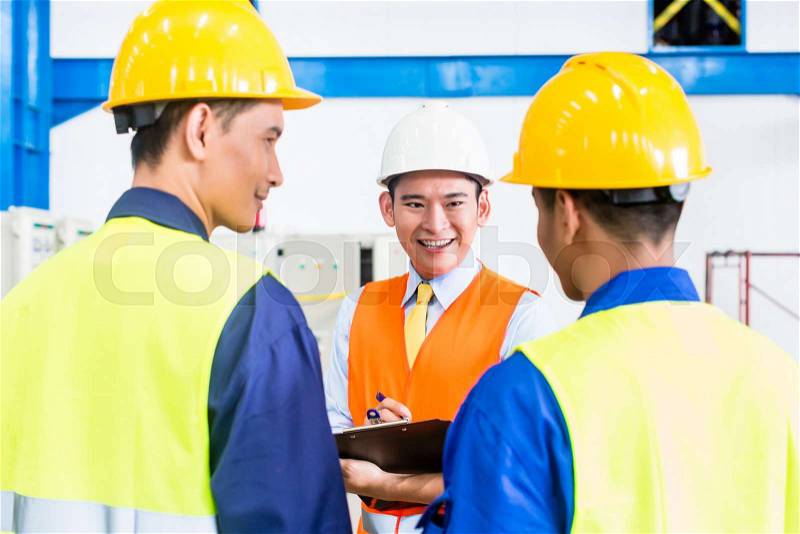 Asian factory worker and engineer as team inspecting a machine delivery, stock photo