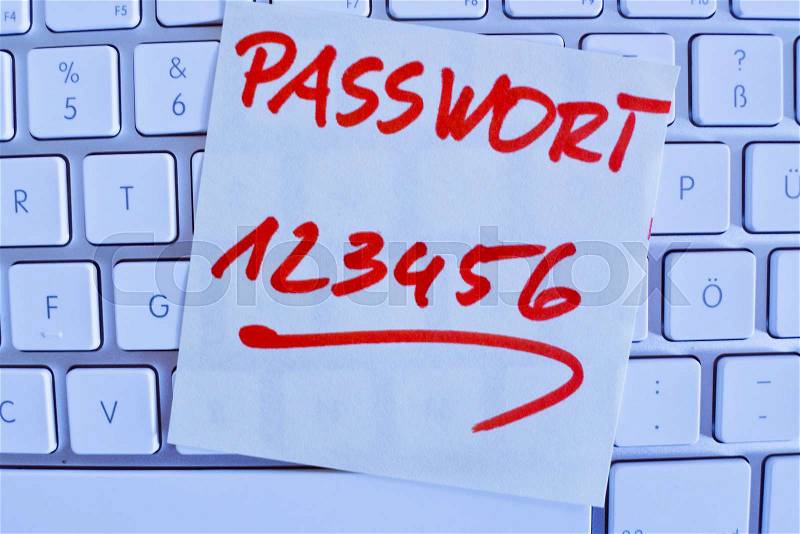 A memo is on the keyboard of a computer as a reminder password 123456, stock photo