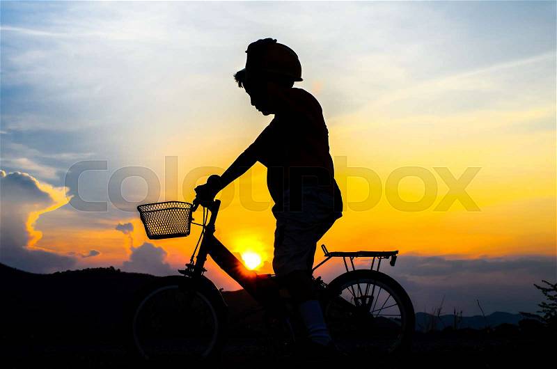 Silhouette of the cyclist riding a road bike at sunset, stock photo