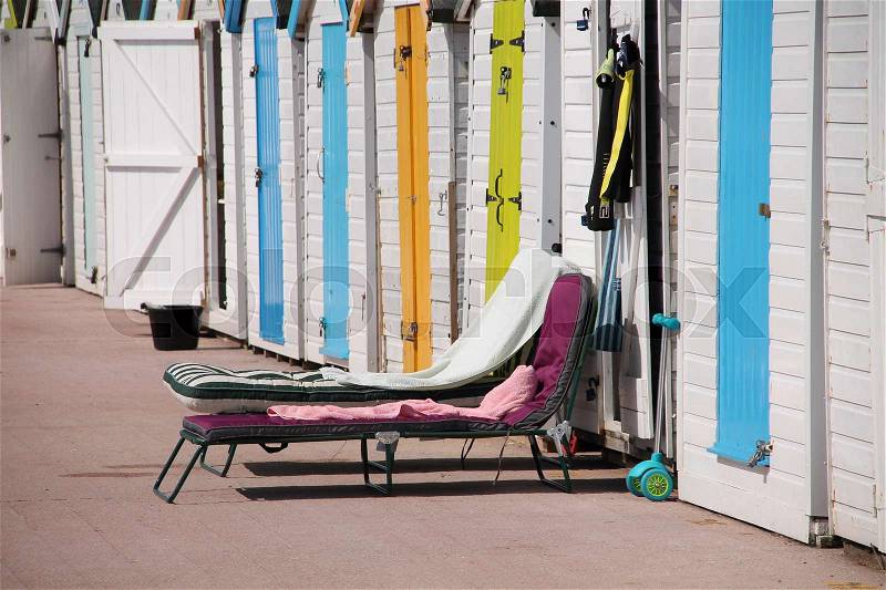 Colourful beach huts and folding beds on the platform in the sun in the summer, stock photo
