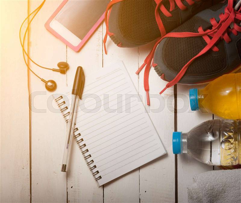 Set for sports activities and notebook on white wooden background,morning light, stock photo