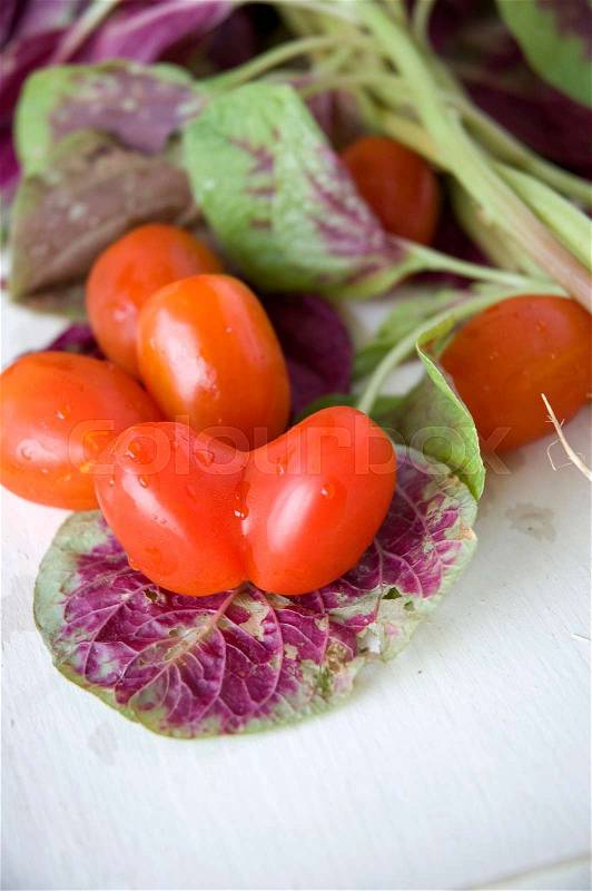 Fresh tomato heart shape with spinach, stock photo