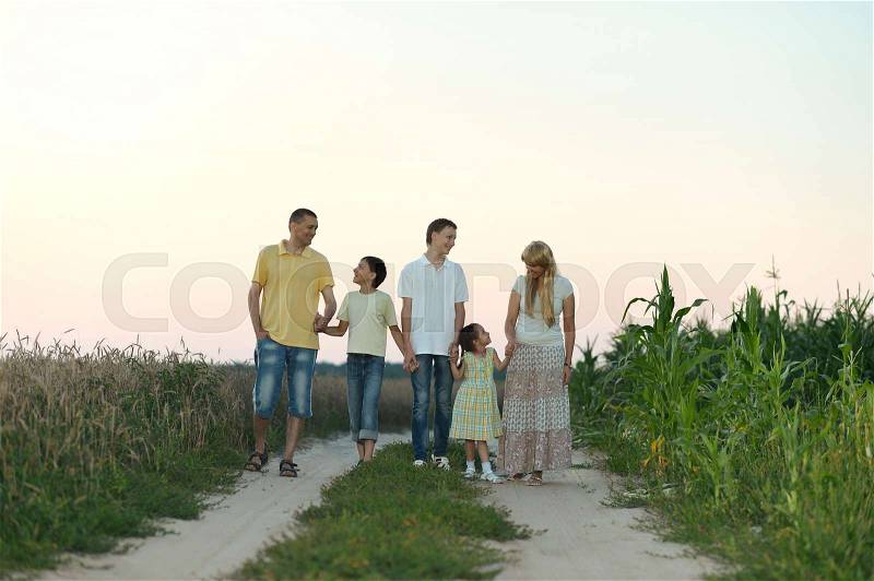 Portrait of a happy family running on field road, stock photo