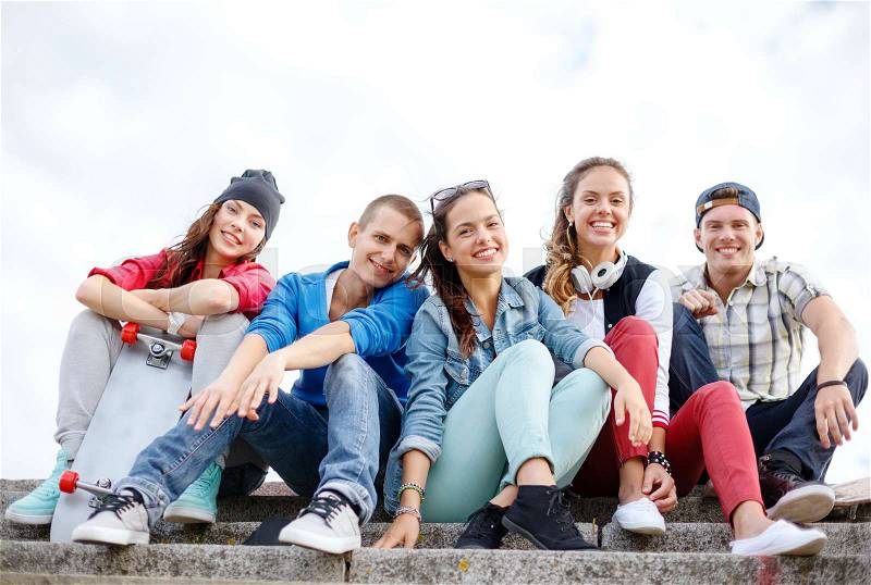 Summer holidays and teenage concept - group of smiling teenagers hanging outside, stock photo
