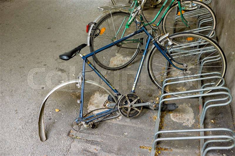 Broken bike in the bike racks, a symbol of bad luck, decay, impermanence, stock photo