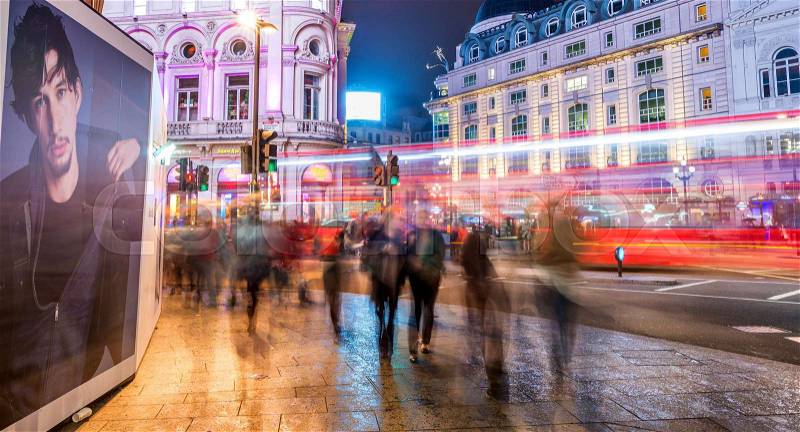 LONDON - SEPTEMBER 28, 2013: Tourists walk along Regent Street at night. More than 40 million people visit London annually, stock photo