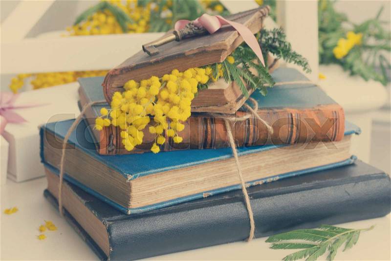 vintage old books with french mimosa flowers, retro toned, stock photo