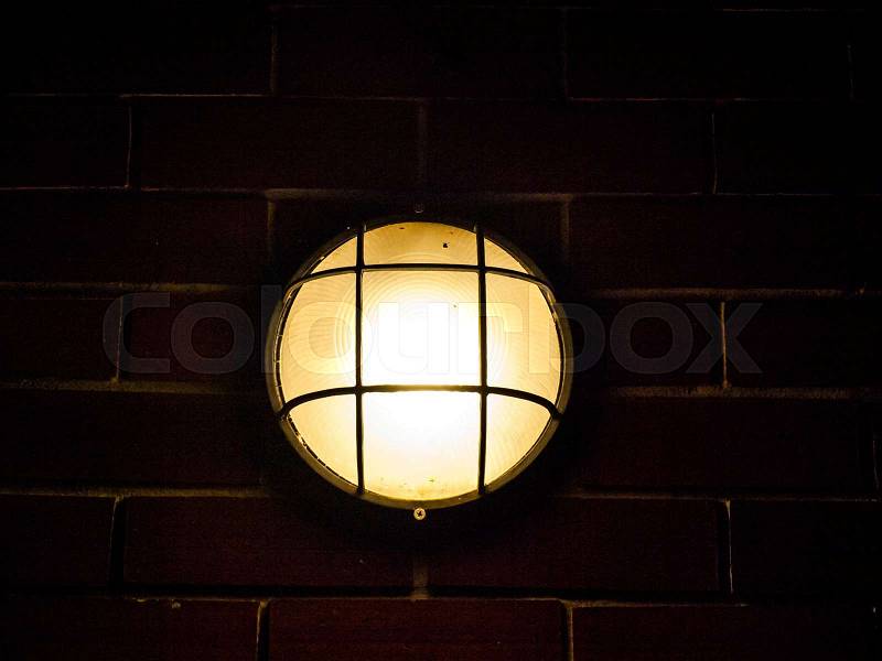 Turn on outdoor lamp on brick wall, stock photo