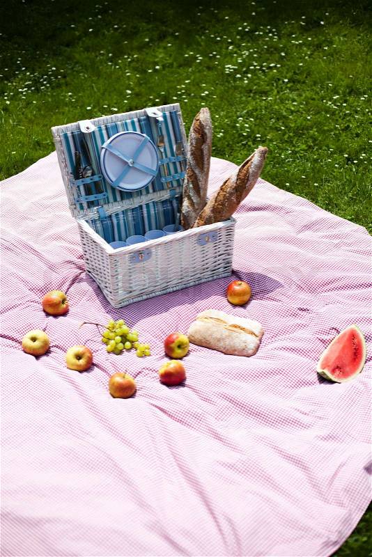 Picnic basket on green lawn, stock photo
